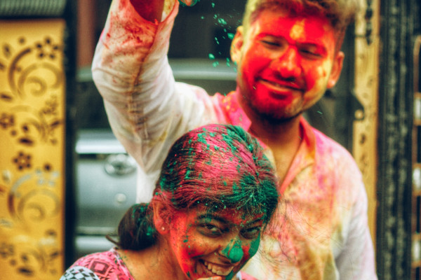 Happy couple playing with colourful powder
